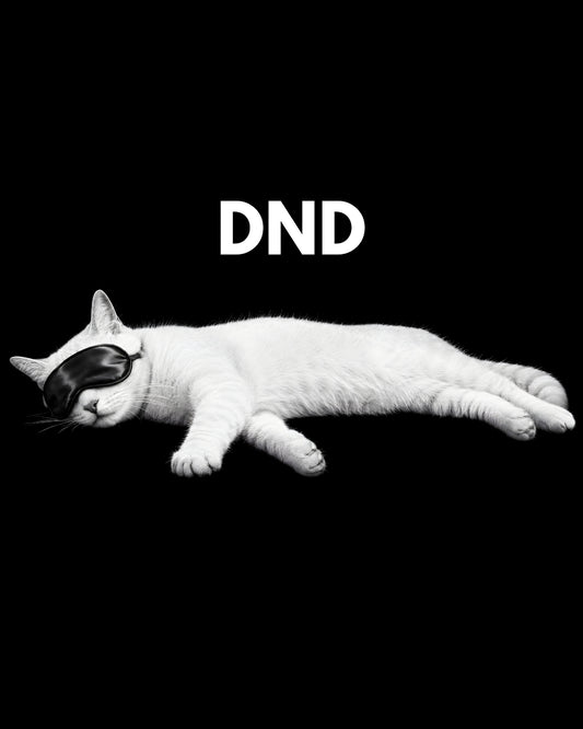 White cat with black mask lying down on a black background with 'DND' text.