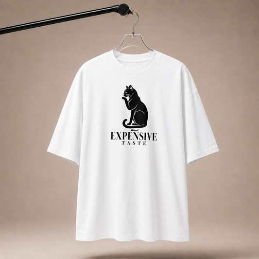 White t-shirt with black cat graphic and text on a beige background