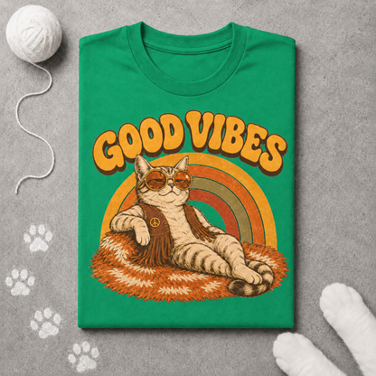 Green t-shirt with a cat graphic and 'Good Vibes' text on a gray surface with paw prints.