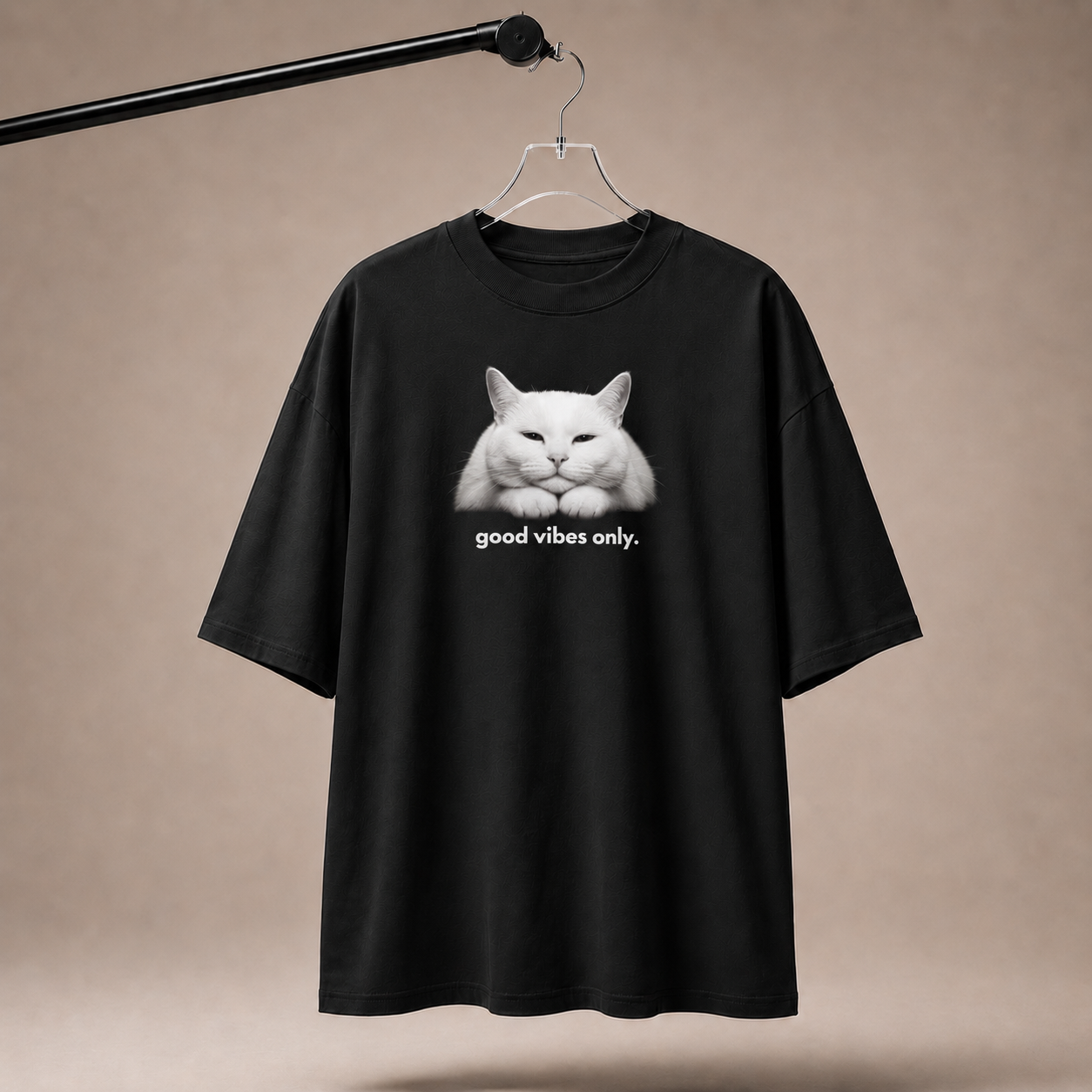 Black t-shirt with a white cat graphic and 'good vibes only' text on a beige background