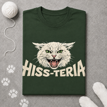 Green t-shirt with a cat graphic and 'HISS-TERIA' text on a gray surface with paw prints.
