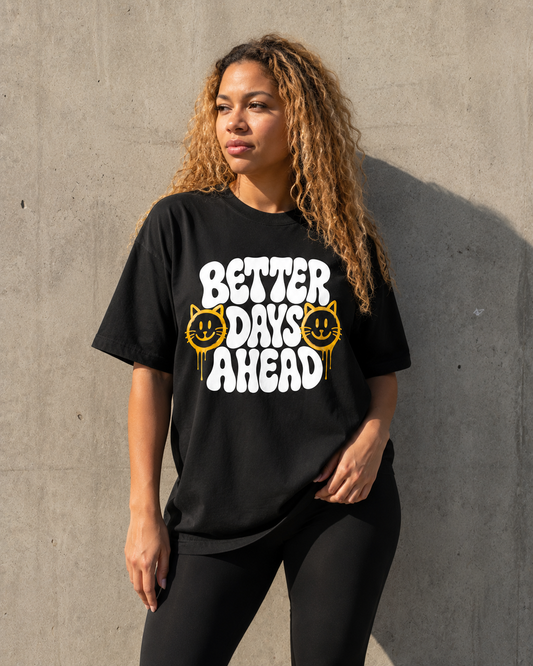 Person wearing a black t-shirt with 'Better Days Ahead' text against a concrete wall.