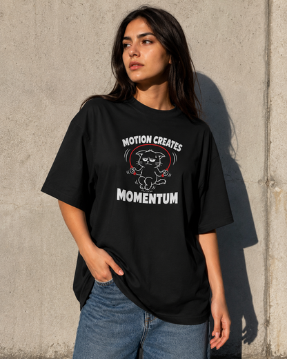 Person wearing a black t-shirt with a graphic and text against a concrete wall.
