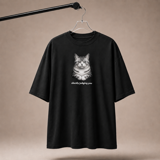 Black t-shirt with a cat graphic and text 'silently judging you' on a beige background