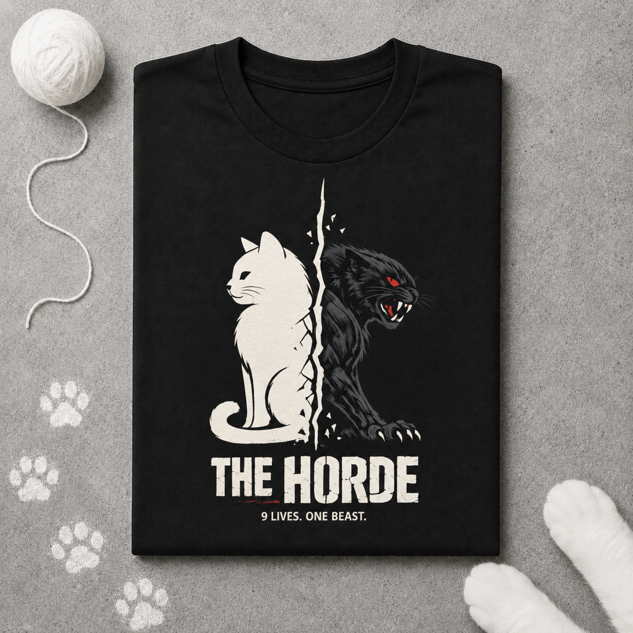 Black t-shirt with cat and panther design and 'The Horde' text on a gray surface with paw prints.