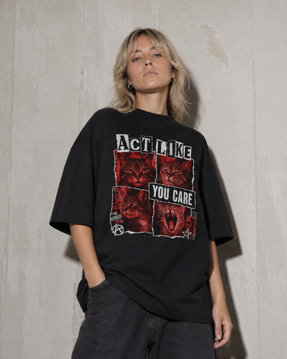 Person wearing a black t-shirt with graphic design and text against a concrete wall.