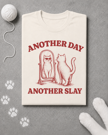 Beige t-shirt with red graphic and text 'Another Day Another Slay' on a gray background