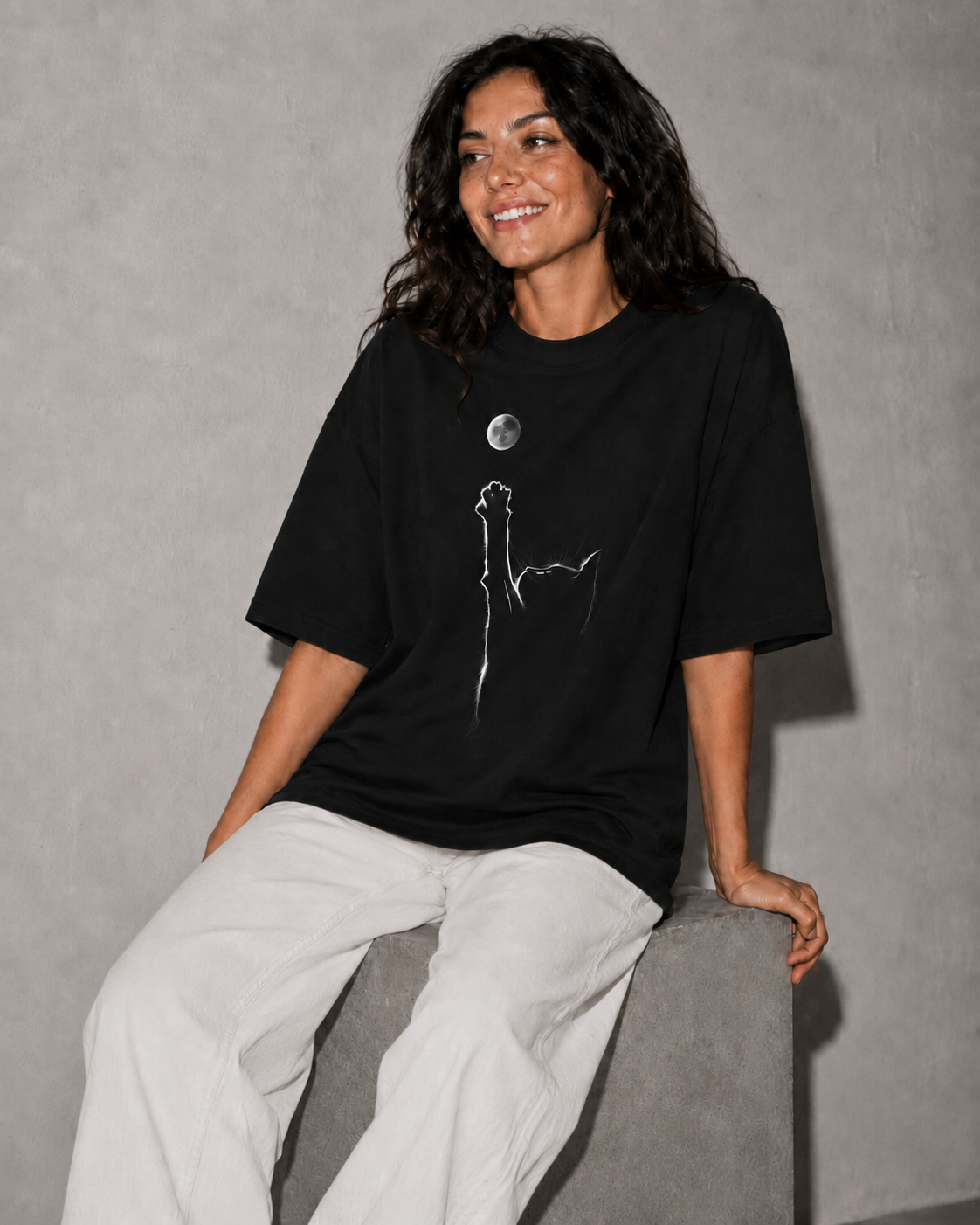 Person wearing a black t-shirt with a white graphic design on a gray background