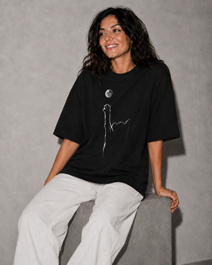 Person wearing a black t-shirt with a white graphic design on a gray background