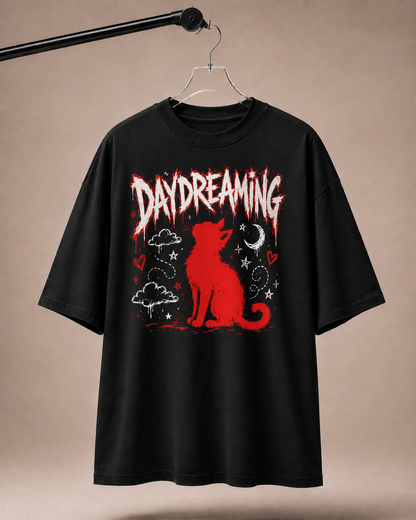 Black t-shirt with red graphic of a cat and 'Daydreaming' text on a beige background