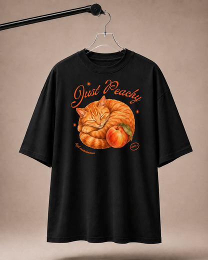 Black t-shirt with a cat and peach graphic and 'Just Peachy' text on a beige background