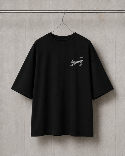 Black t-shirt with a small white graphic on a gray textured wall