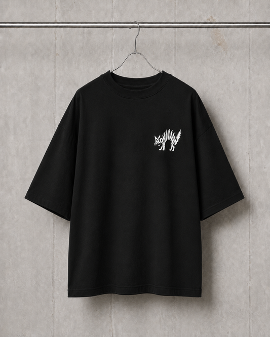 Black t-shirt with a white graphic on a hanger against a gray concrete wall