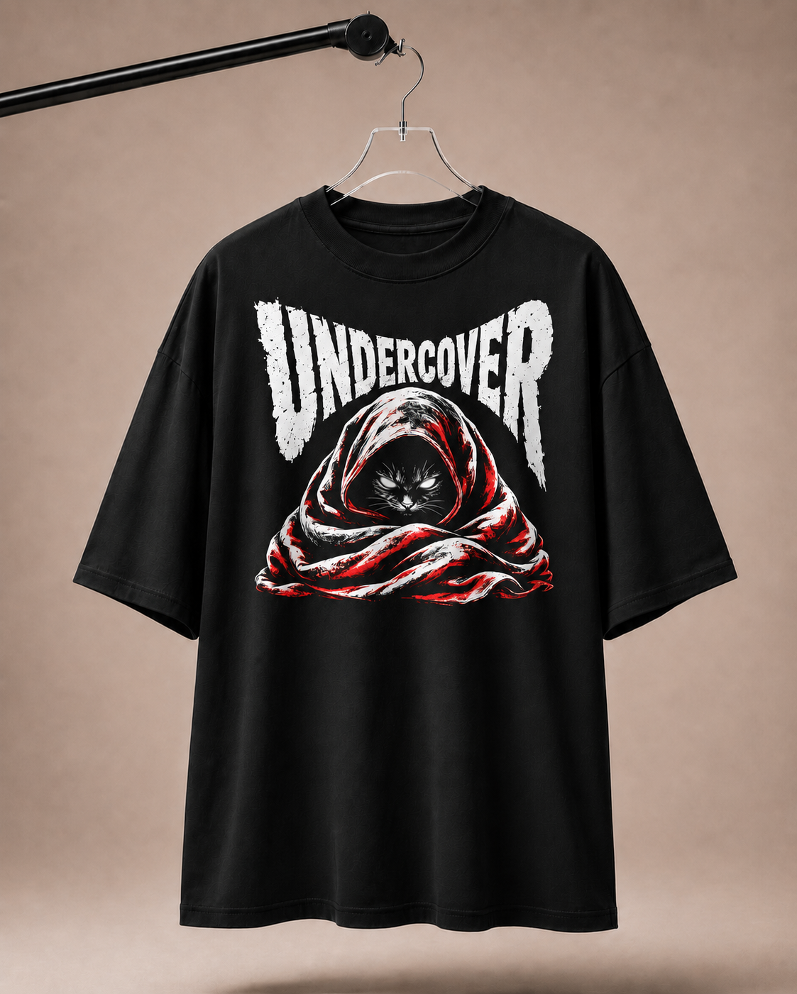 Black t-shirt with 'Undercover' graphic design on a beige background